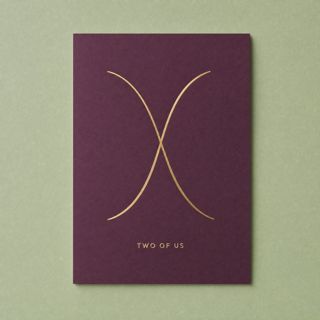 Two of Us card: two gold foil arcs crossing once on a deep plum card