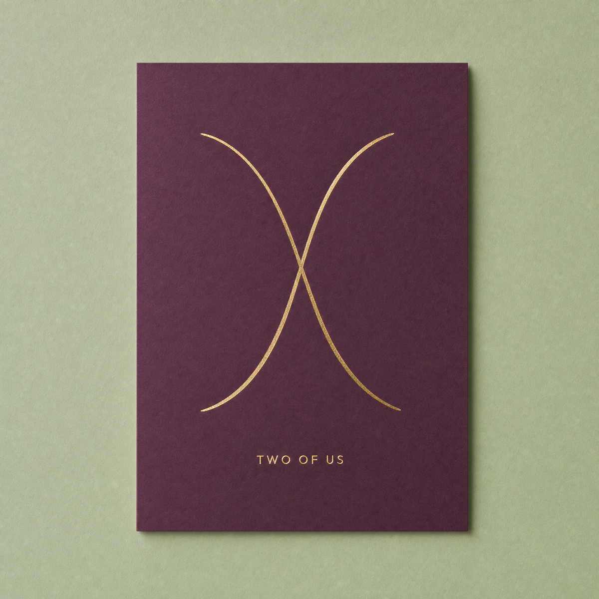 Two of Us card: two gold foil arcs crossing once on a deep plum card